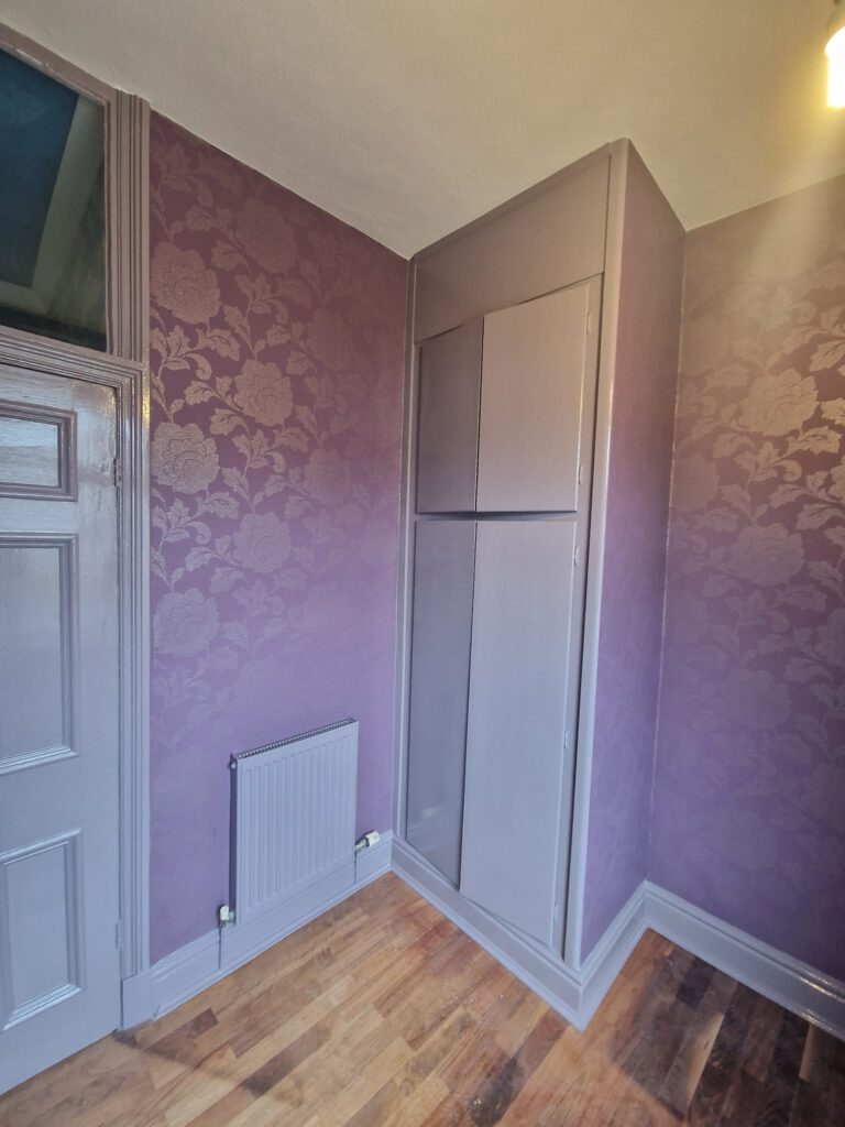 Landing with purple damask wallpaper and grey painted woodwork