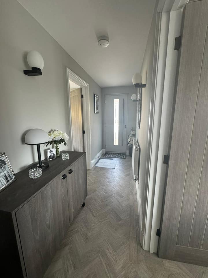 Hallway painted in soft grey with herringbone flooring