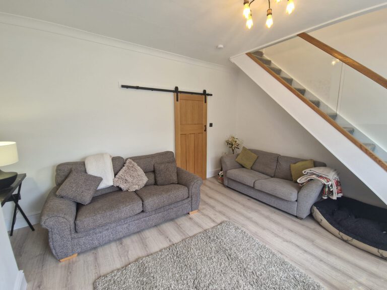 Bright white living room with an oak barn door