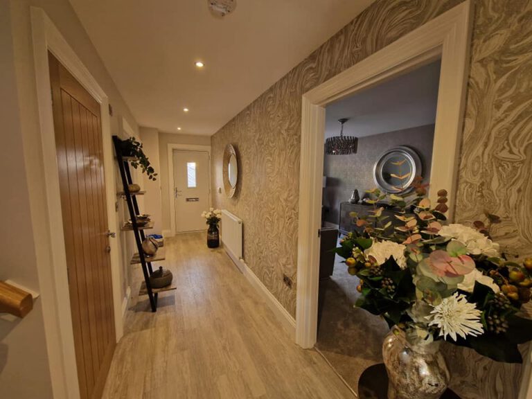 Gold marble-effect wallpaper in a hallway with oak doors