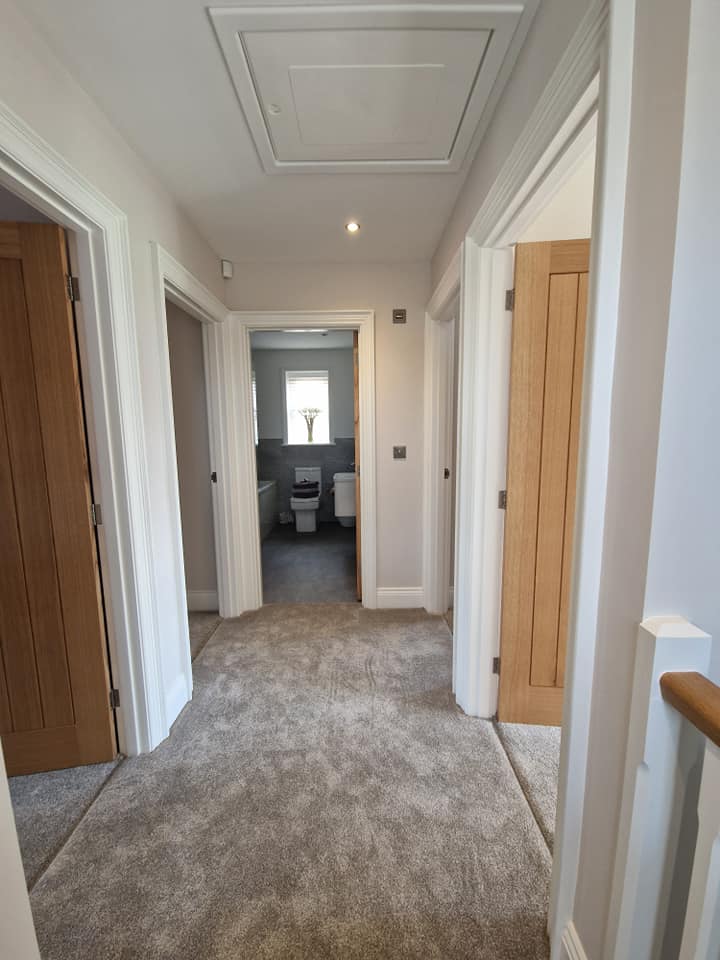 Landing with white walls and oak doors
