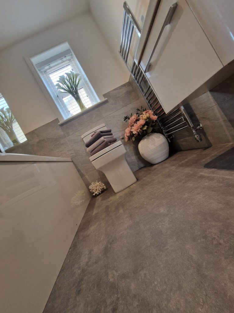 Bathroom with grey stone-effect walls and white units