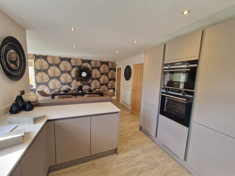 Kitchen with bold dark leaf-pattern feature wallpaper
