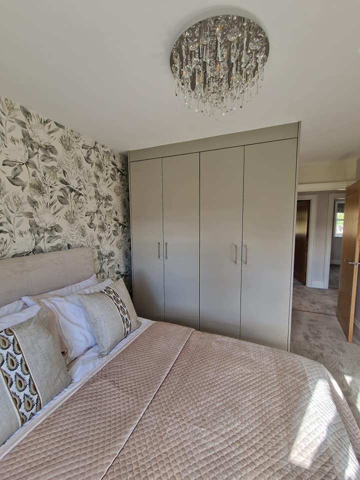 Bedroom with black and white floral wallpaper behind the bed