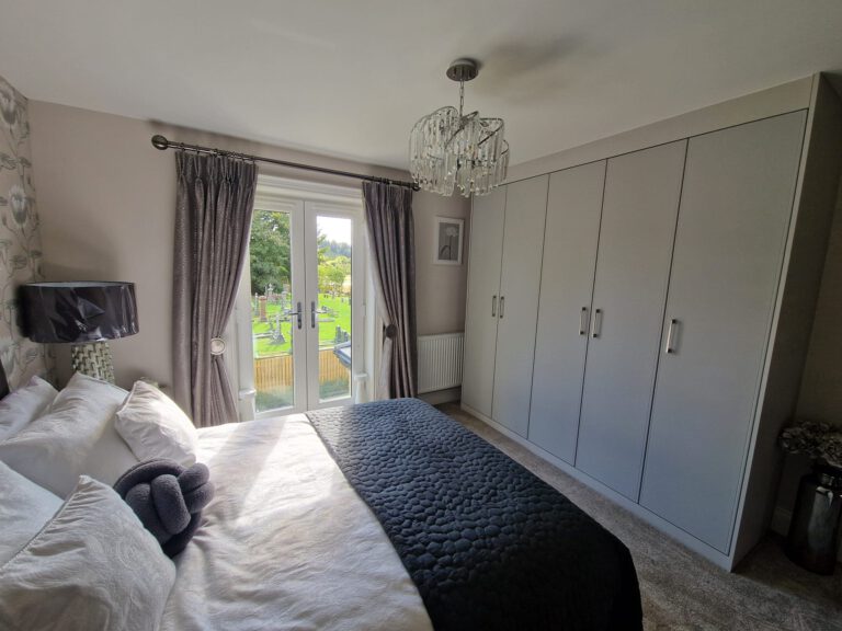 Bedroom with grey fitted wardrobes and French doors