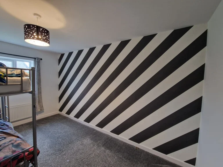 Bedroom with black and white diagonal stripe wallpaper